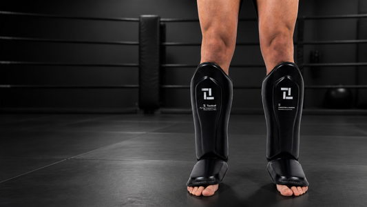 TFW Apex Series scheenbeschermers voor kickboksen en MMA in een donkere gym